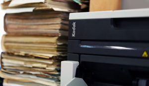 Stack of files next to a scanner